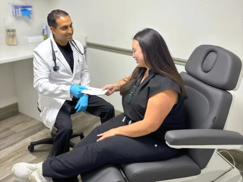 Dr. Sundeep Shah, nephrologist at Evolve Health, going over a lab result with a patient in an exam room