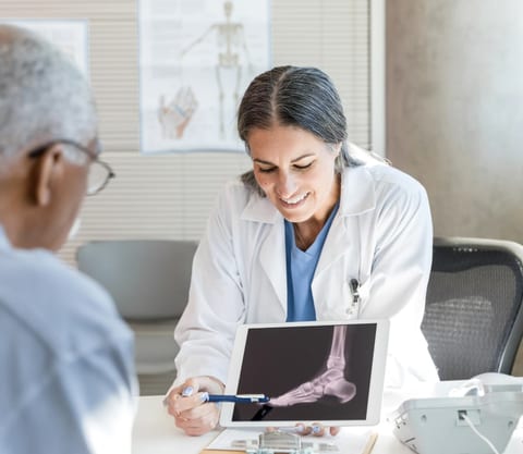 An Evolve Health physician reviewing a care plan on a tablet with a patient
