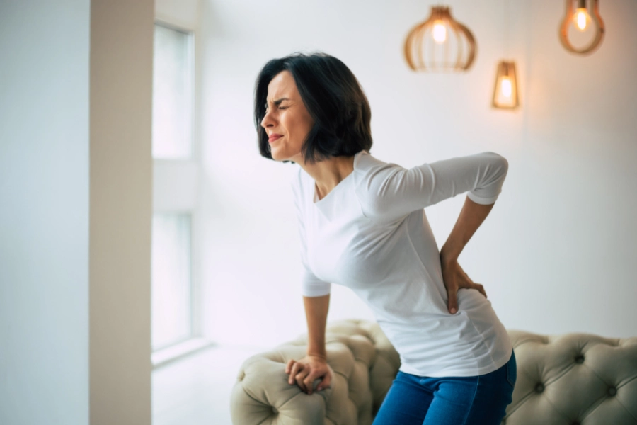 Woman experiencing lower back pain — Evolve Health explains how custom orthotics relieve knee, back, and hip pain by improving posture and alignment.